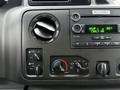 Dashboard controls of a 2013 Ford E-350 including knobs for temperature and air circulation with a digital radio display