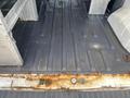 Interior view of a 2013 Ford Transit Connect showing a rusty metal floor with visible grooves and scratches