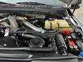 The image shows the engine compartment of a 2020 Ford F-350 highlighting various components including the air intake system coolant reservoir and battery