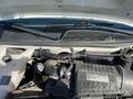 Engine compartment of a 2012 GMC Savana showing the Vortec engine and various components including hoses and the windshield wiper system