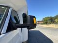A 2017 Chevrolet Express van with a side mirror featuring an orange light indicator
