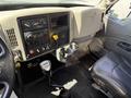 Interior cockpit of a 2009 International 7500 featuring a dashboard with various controls gauges and a gear shift along with a driver's seat and cup holder