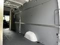 Interior of a 2023 Mercedes-Benz Sprinter van showing a spacious cargo area with grey wall panels and a smooth floor