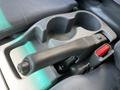 Close-up of the gear shift and cup holder area in a 2007 GMC W3500 featuring a black gear lever and a red button on the side