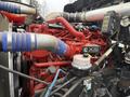 Close-up of a red X15 engine with blue hoses and various pipes visible in the foreground showing detailed mechanical components