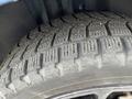 Close-up of a winter tire with deep treads mounted on a 2022 Dodge Charger showcasing its grip design