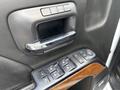 Close-up of the interior door panel of a 2017 Chevrolet Silverado 1500 featuring a chrome door handle and a set of power window and lock controls