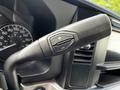 A close-up of a control lever in a 2024 Ford F-550 featuring a plus and minus button for adjusting settings