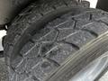 Close-up of a heavy-duty tire from a 2010 Freightliner M2 106 showcasing deep tread patterns and rugged texture designed for enhanced traction and durability