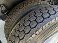 Close-up of the tread on two thick tires of a 2005 Volvo VND 122 showing a hexagonal pattern indicating heavy-duty use