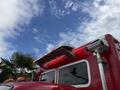A red 2007 Ford F-550 emergency vehicle with a light bar on the roof and reflective lights on the sides