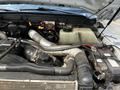 The engine compartment of a 2016 Ford F-550 with visible components including pipes hoses and a coolant reservoir