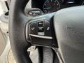 Steering wheel controls of a 2023 Ford Transit with buttons for volume and voice commands