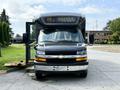 A black 2020 Chevrolet Express van with its side door open, showing a spacious interior and a Chevrolet emblem on the front grille