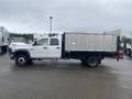 A 2008 Dodge Ram 5500 with a flatbed and metal sides parked on a wet surface