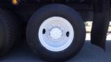 A large truck tire mounted on a white wheel featuring six lug nut holes and a smooth surface