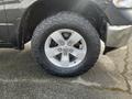 A close-up of a tire mounted on a silver alloy wheel showcasing the rugged tread pattern typical of a 2015 RAM 1500 pickup truck