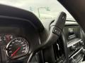 Interior view of a 2016 GMC Sierra 1500 showing the steering wheel controls and speedometer with a focus on the gear shift lever and instrument panel