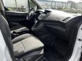 Interior of a 2016 Ford Transit Connect featuring two front seats a steering wheel and center console with controls and storage compartments