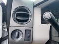 Dashboard controls and air vent of a 2009 Ford F-450 SD with dials for lights and air circulation