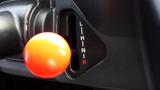 Close-up of a Kubota RTV X1100c gear shift lever with an orange knob and a panel displaying L H N I R markings