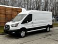 A white 2020 Ford Transit van with a black stripe along the bottom and silver wheels parked in a commercial area