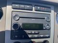 A close-up of the dashboard controls of a 2013 Ford Expedition showing the radio display and various buttons for adjusting settings and volume