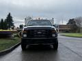 A black 2009 Ford F-550 truck with a prominent grille and yellow lights on top facing the viewer