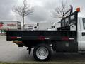 2015 Ford F-550 flatbed truck with a black bed and railing visible from the side