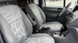 Interior view of a 2012 Ford Transit showing two gray patterned front seats and the steering wheel with dashboard controls