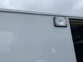 A 2014 Chevrolet Express van with a white exterior and a side light fixture