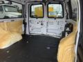 Interior of a 2012 Chevrolet Express van stripped and coated in yellow insulation with a black rubber floor and clear windows