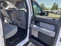 Interior view of a 2014 Ford F-150 showing the backseat and door panel with gray fabric and plastic elements