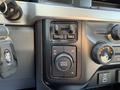 A close-up of the control panel in a 2023 Ford F-550 featuring buttons for drive mode and settings for two-wheel and four-wheel drive along with a key fob