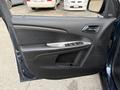 The image shows the interior door panel of a 2013 Dodge Journey featuring a door handle power window controls and speaker grille