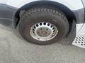 Close-up of a 2009 Dodge Sprinter Van tire featuring a silver wheel rim with circular holes and rugged tread pattern