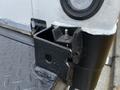 Close-up of a heavy-duty truck's rear light housing with a partially exposed electrical connector on a textured surface