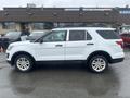 A white 2016 Ford Explorer is parked with its side facing the viewer showcasing its four doors and five-spoke wheels