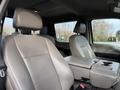 The interior of a 2020 Ford F-550 featuring two light gray front seats with armrests and a center console between them