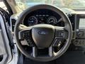 Steering wheel of a 2022 Ford F600 with buttons and the Ford logo visible in the center