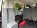 Interior of a 2017 Ford Transit showing a red toolbox and black seats with a gray wall section on the left