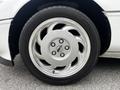 Close-up of a silver wheel from a 1992 Chevrolet Corvette featuring a distinctive five-spoke design and a prominent Corvette emblem in the center