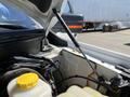 A 2014 Ford F-150 with the hood lifted showing the engine compartment and various components including a yellow cap on the coolant reservoir and support struts
