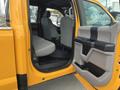 A 2017 Ford F-250 SD in bright yellow with an open door revealing a spacious interior featuring gray seats and a black floor mat