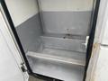 Interior of a 2003 Ford F-450 SD with a metal shelf and gray walls showing some rust and wear
