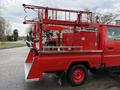 A red 2001 Toyota Dyna fire truck with a mounted ladder and equipment storage compartments on the rear