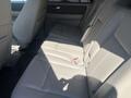 The interior of a 2013 Ford Expedition featuring beige leather seats in the second row with ample legroom and a spacious layout