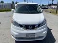 A white 2019 Nissan NV200 van is parked facing the camera with a clear view of its front grille headlights and windshield