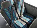 Interior seats of a 2022 Blue Bird BB Conventional bus featuring a gray fabric with blue and turquoise patterned designs and seatbelts