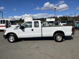 A white 2013 Ford F-250 SD pickup truck with a standard cab and long bed parked on a paved surface
